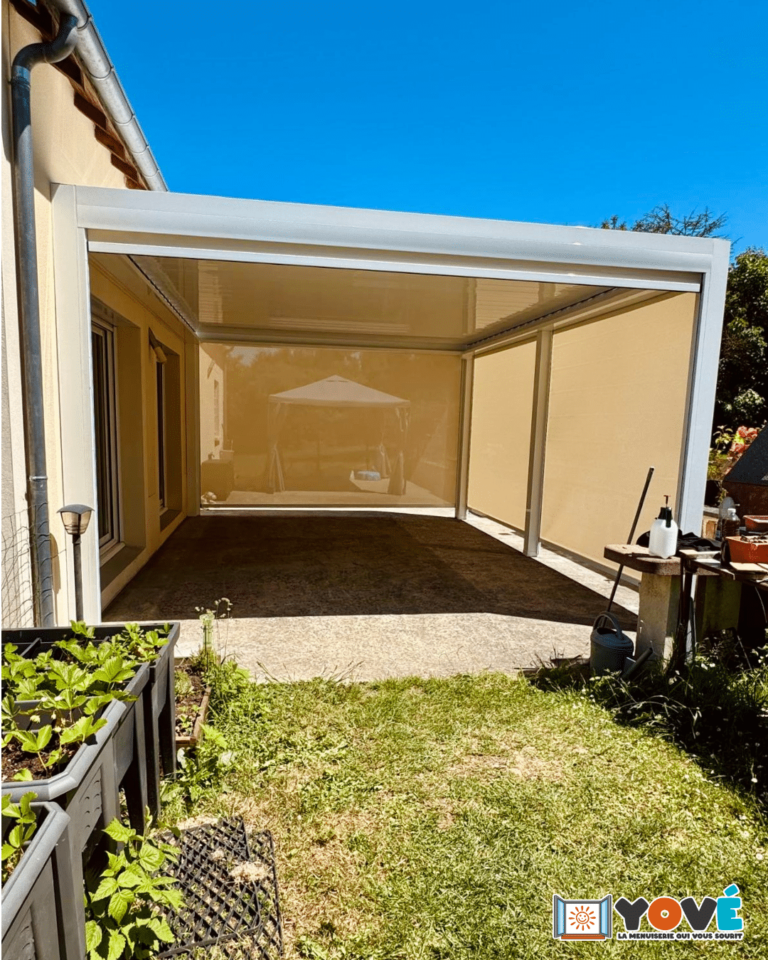 Pergola bioclimatique Open de chez Marquises à Episy équipée de stores verticaux pour une protection solaire latérale et une meilleure intimité